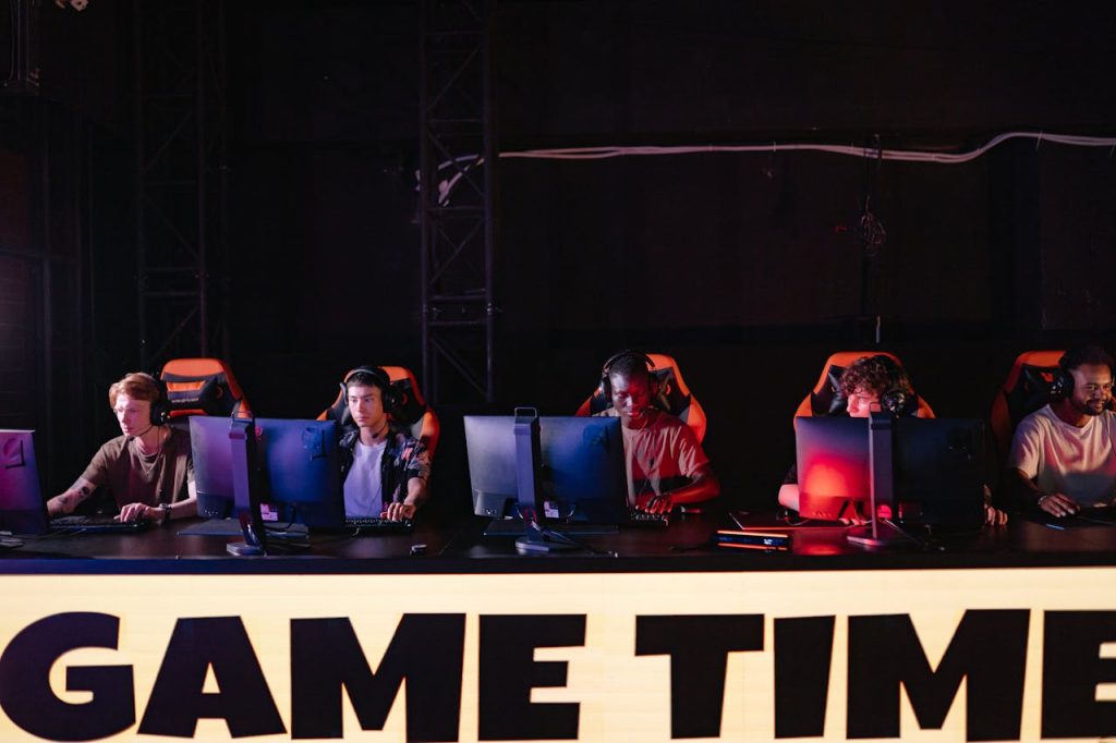 Beginner’s Guide to Gaming Terms: From “NPC” to “GG” A group of diverse gamers participating in an online eSports tournament indoors.
